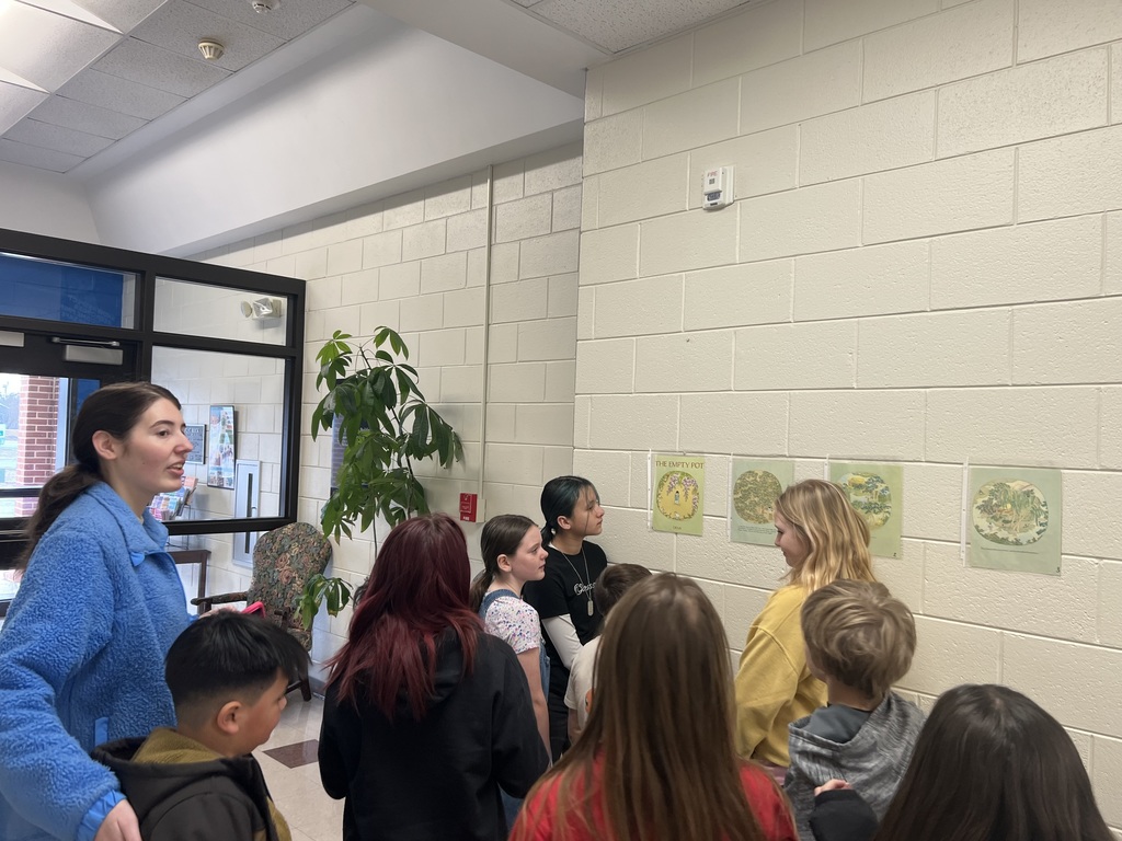students reading during a story walk through the halls