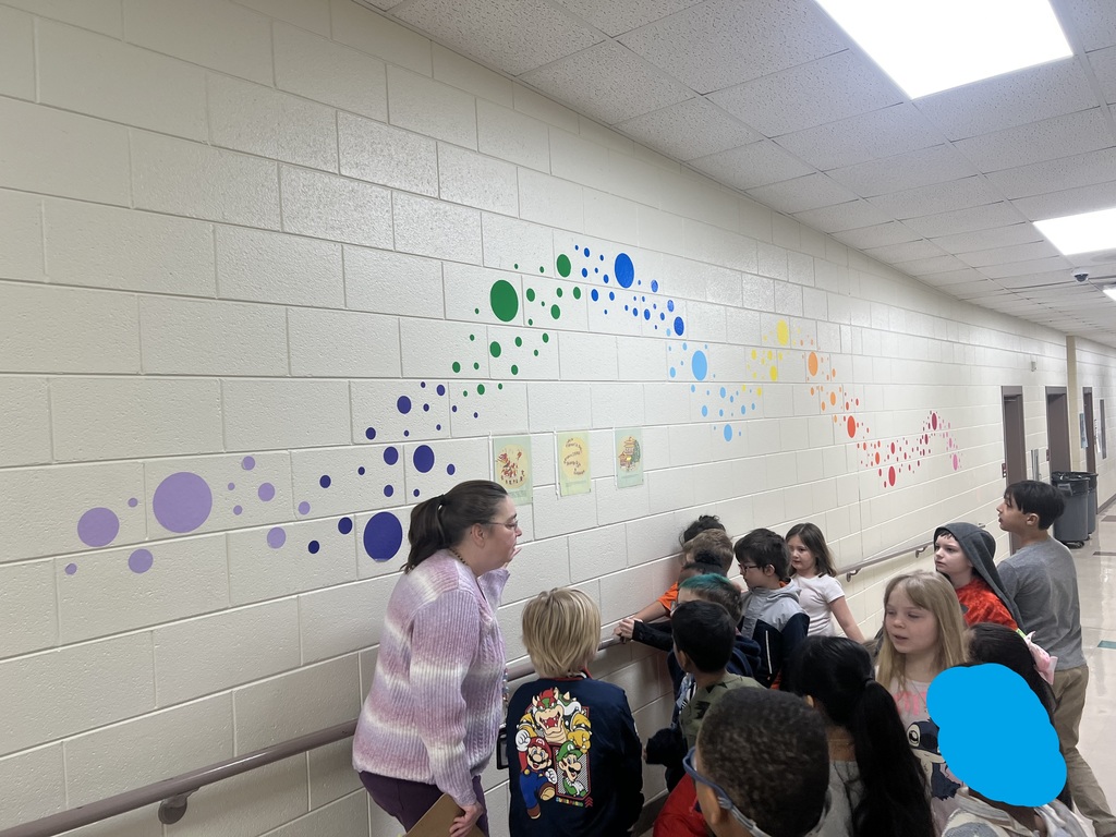 students reading during a story walk through the halls