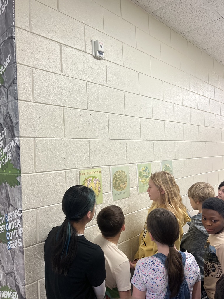 students reading during a story walk through the halls