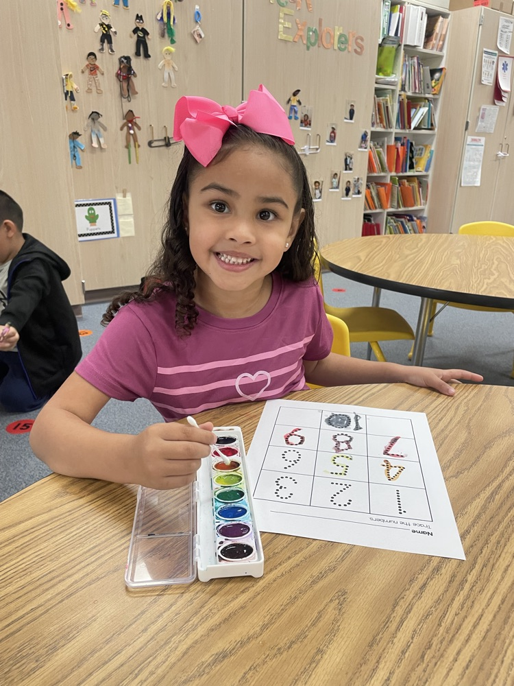 student tracing numbers with paint