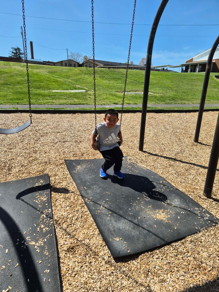 pre k students playing on the big kid playground 