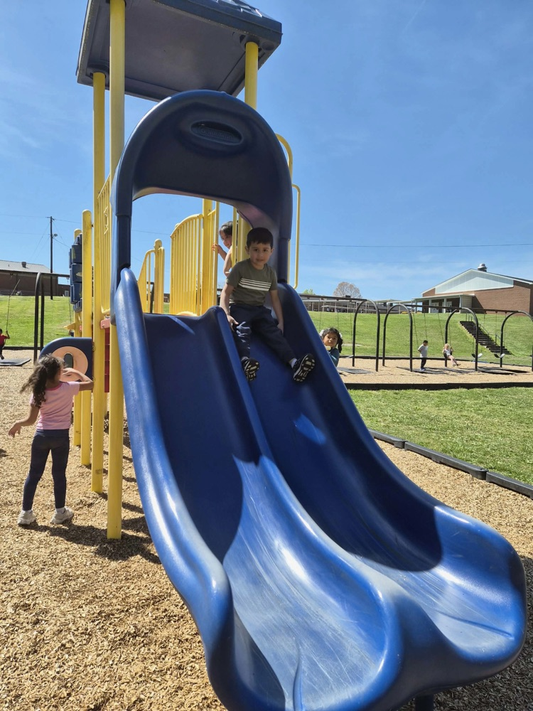 pre k students playing on the big kid playground