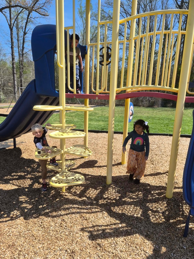 pre k students playing on the big kid playground