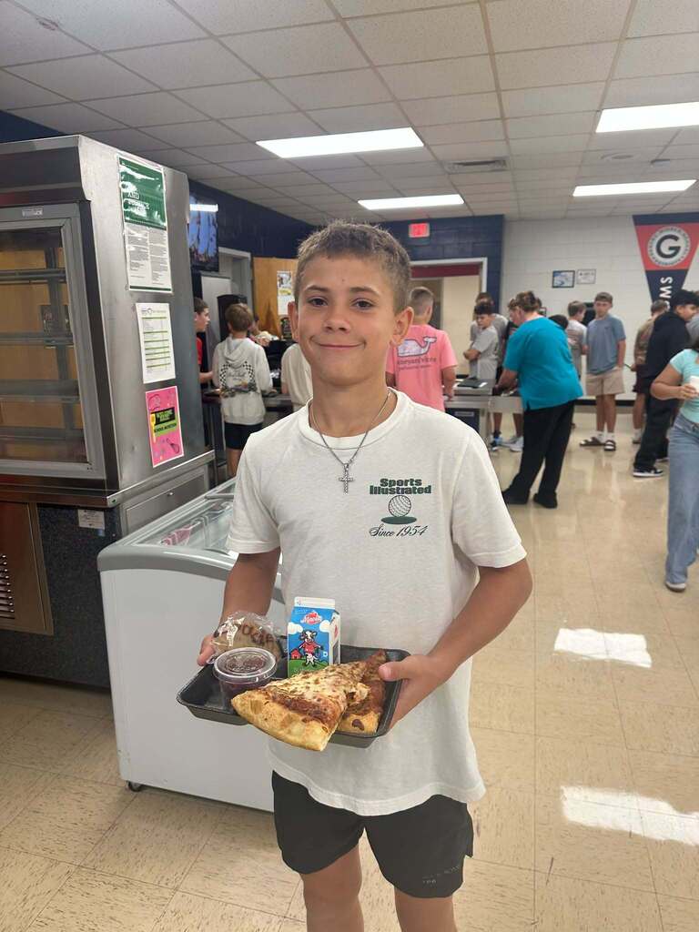 Student poses with his lunch plate at GMS