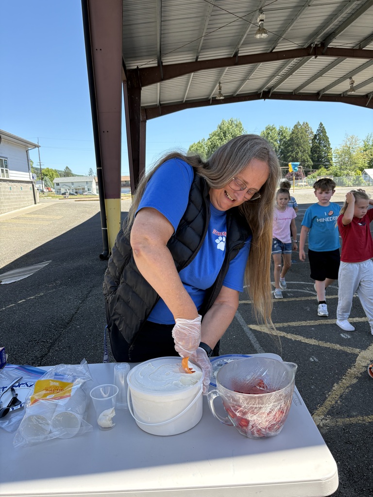 Picture of teacher scooping strawberries and ice cream for 2nd graders