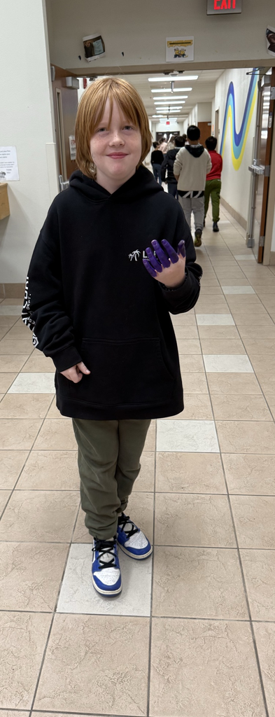 Fifth Grader showing off their purple fingers.