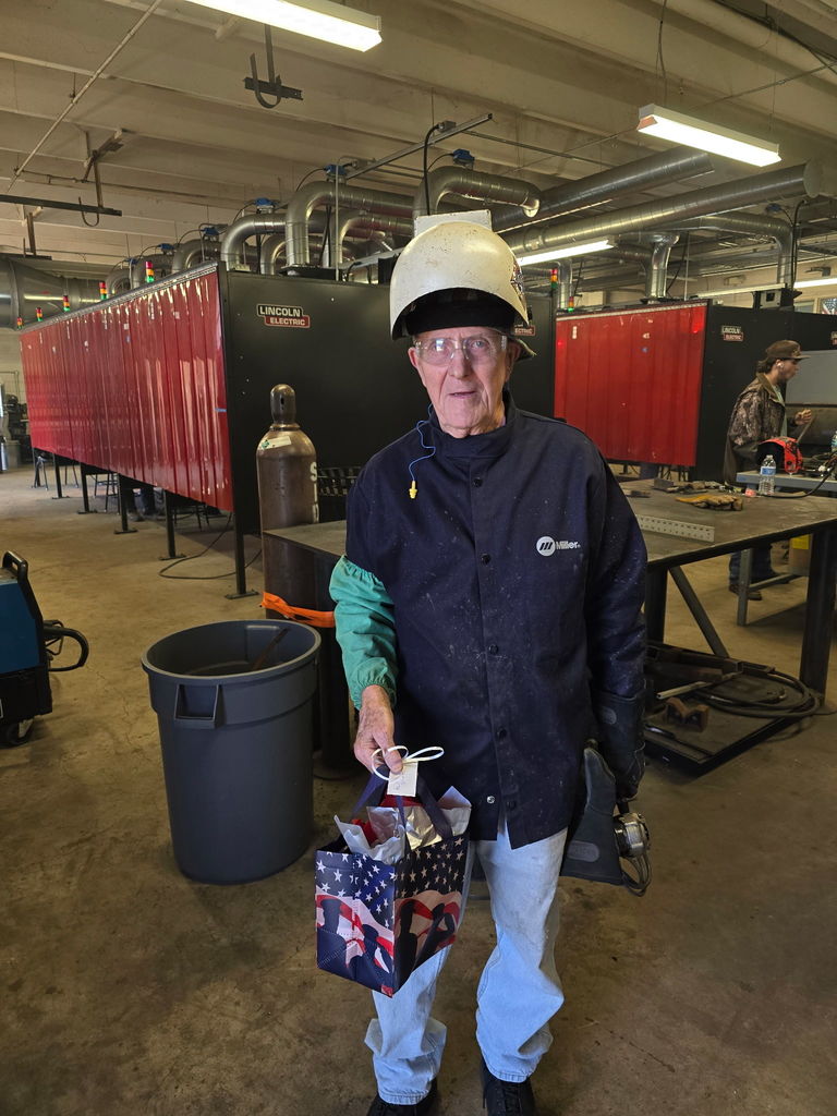 Welding student with gift bag in welding lab