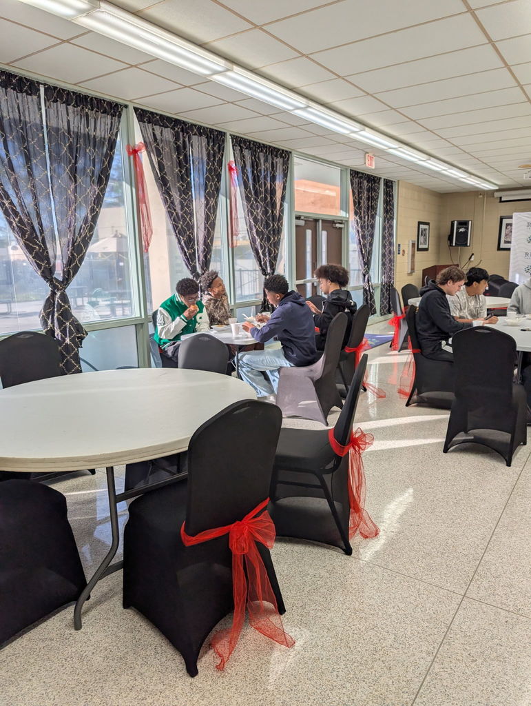 Students sitting down and eating breakfast