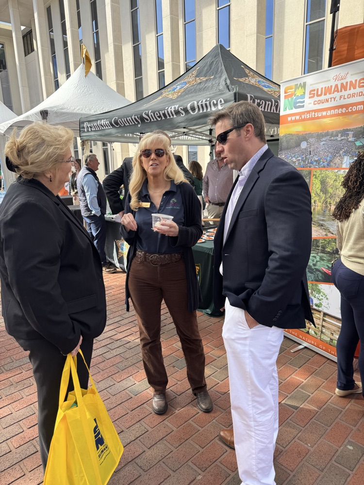 Julie Ulmer and Clay Tomlinson talking with person