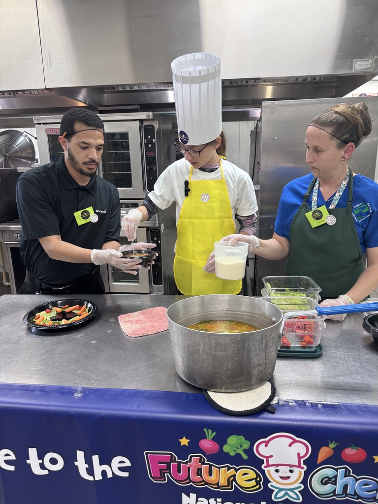 Lillyanna Ott preparing her dish with Sodexo employees 