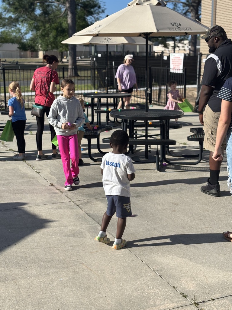 Students outside on the patio area looking for easter eggs