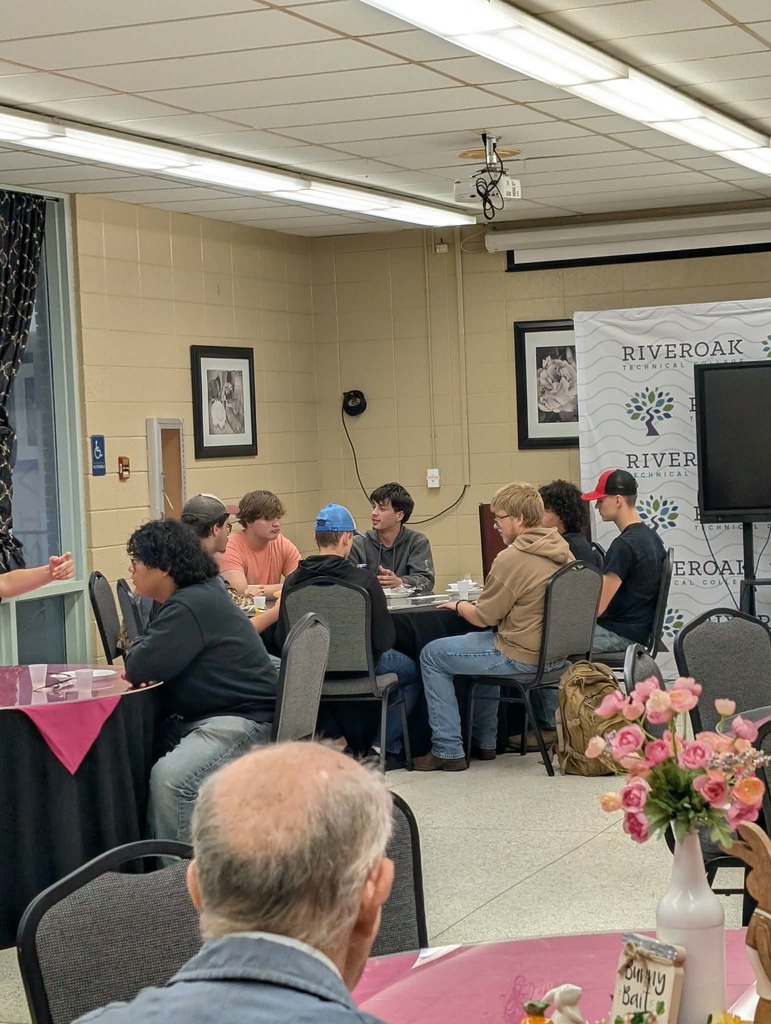 Male students sitting at table eating breakfast