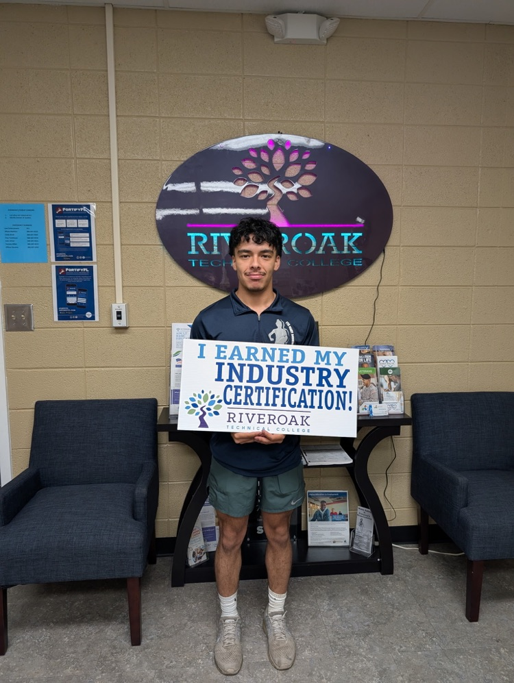 Nathaniel Rojas smiling with a sign