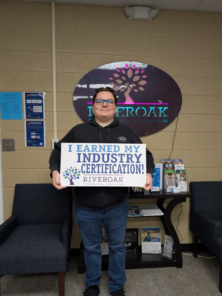 Jeremy Giddens smiling with a sign