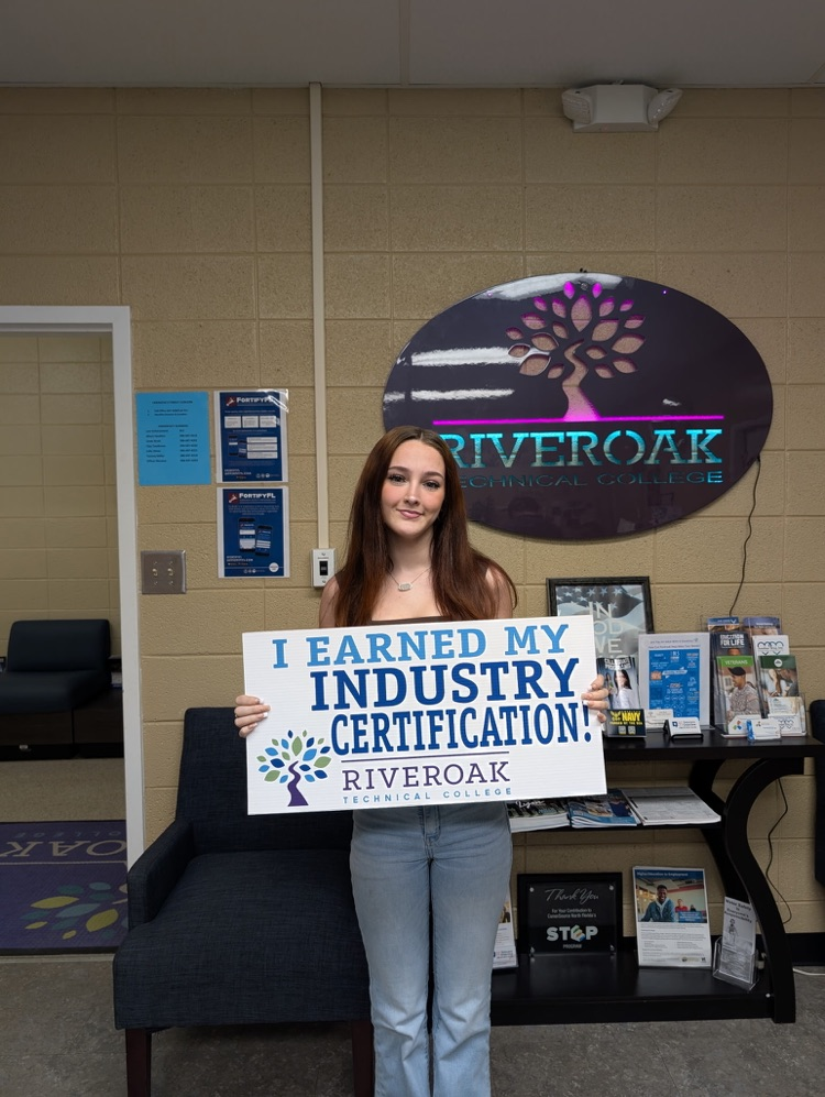 Kelsey Kelkites smiling with a sign