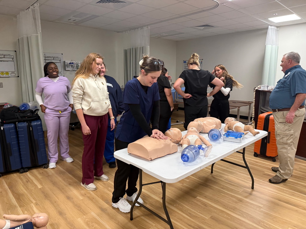 Student performing CPR while fellow students watch