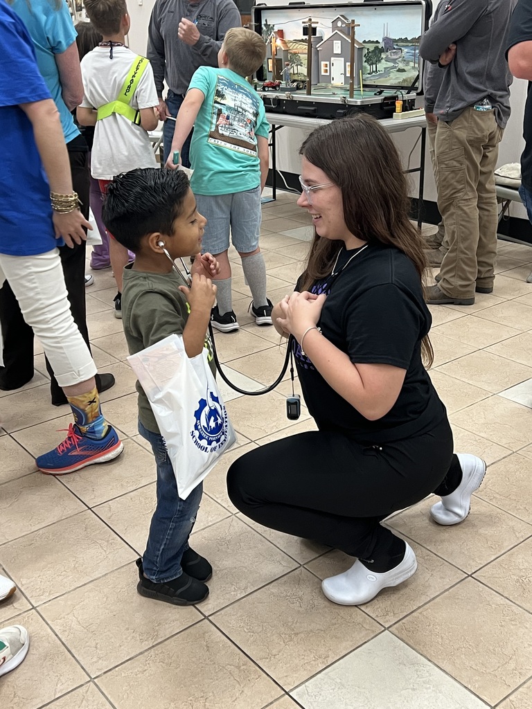Young child listens to a Practical Nursing student's heart beat