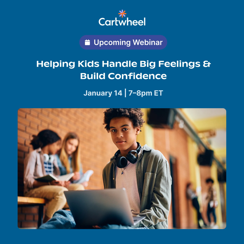 Young man looking at camera with a laptop open in front of him.