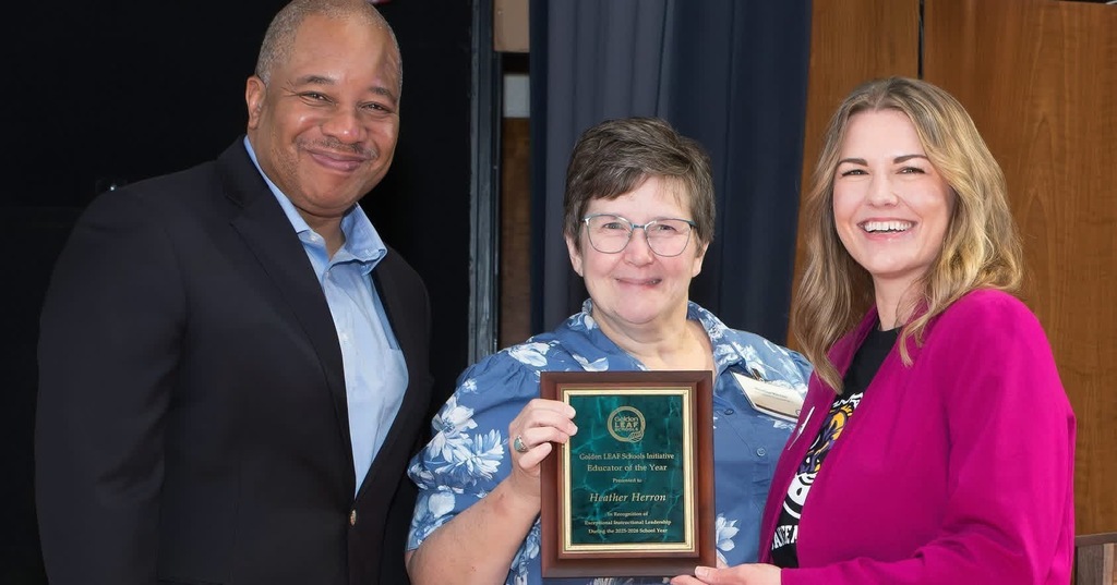 Man and two women with plaque.