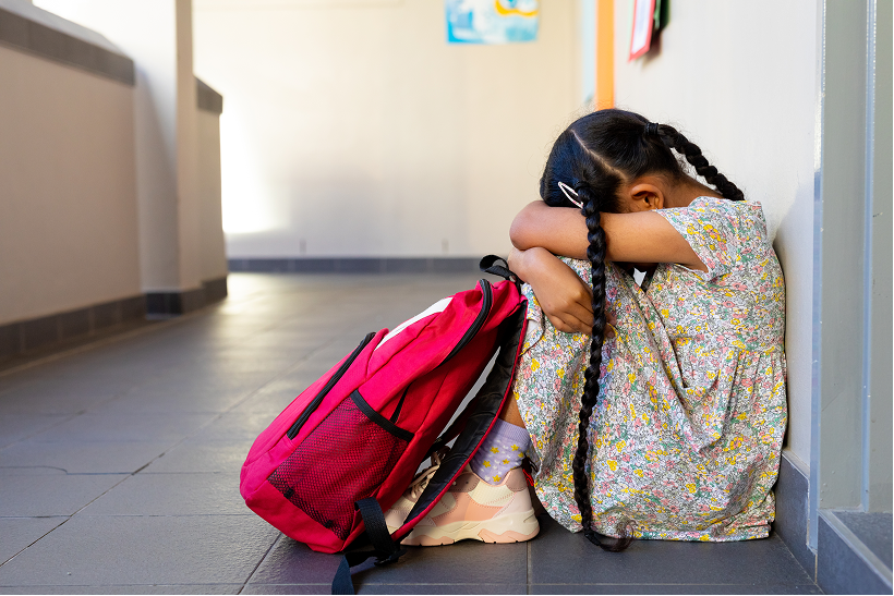 Little girl with red backpack head down