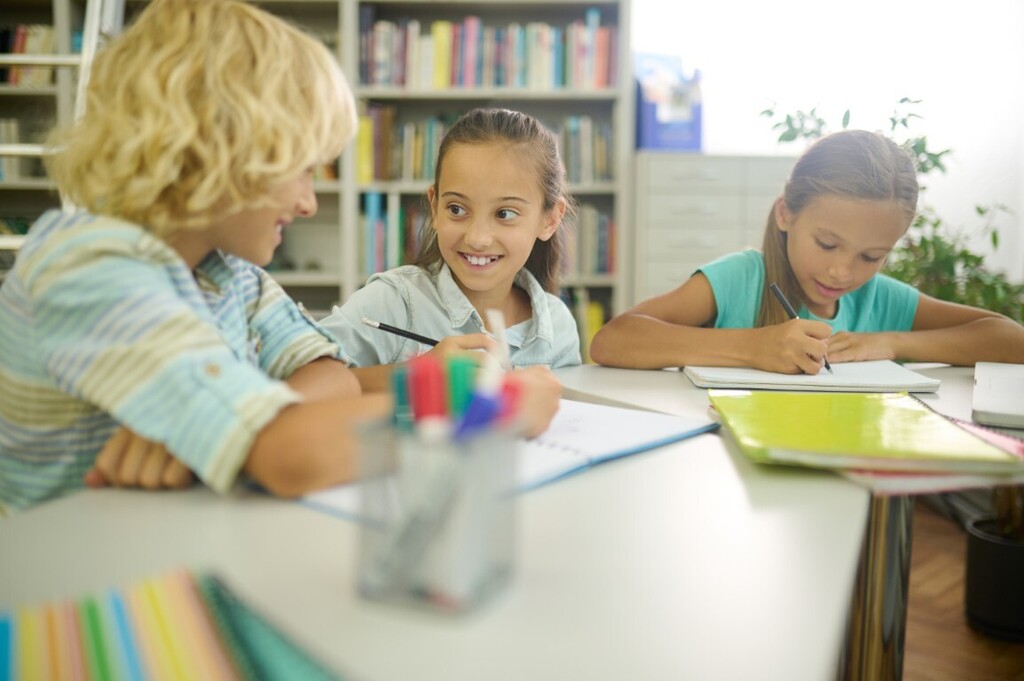 Three students working at a table.