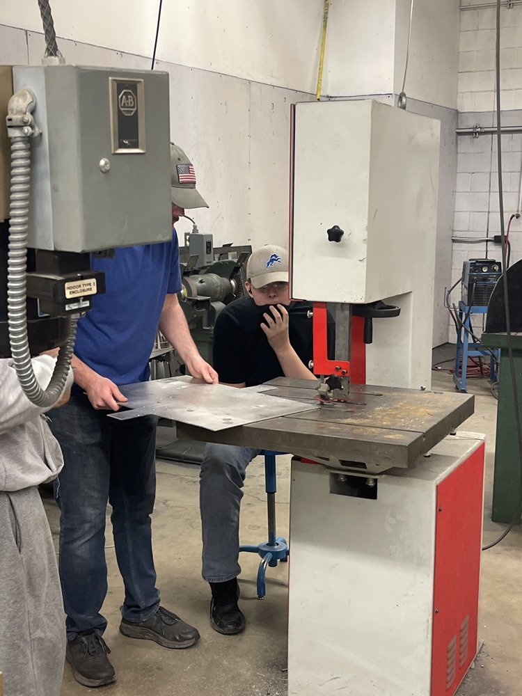 mentor training students on bandsaw