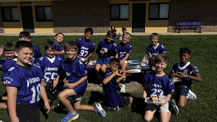 A bunch of fourth grade Vikings are eating lunch outside while enjoying the sunshine.