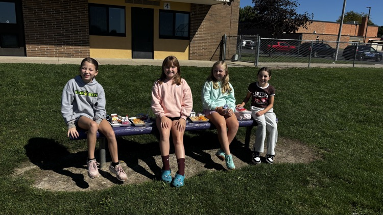 A bunch of fourth grade Vikings are eating lunch outside while enjoying the sunshine.