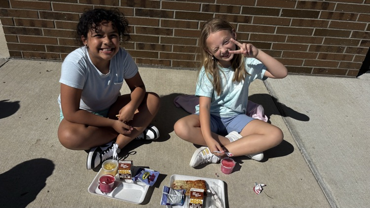 A bunch of fourth grade Vikings are eating lunch outside while enjoying the sunshine.