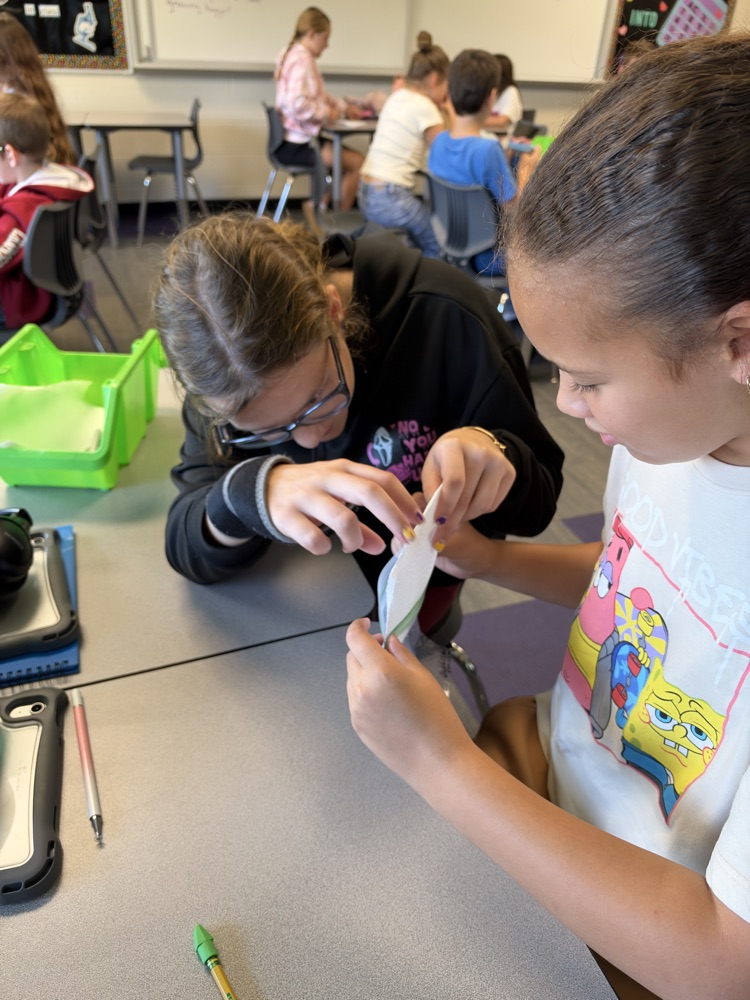Two fifth grade students setting up their bag and seed for a science experiement