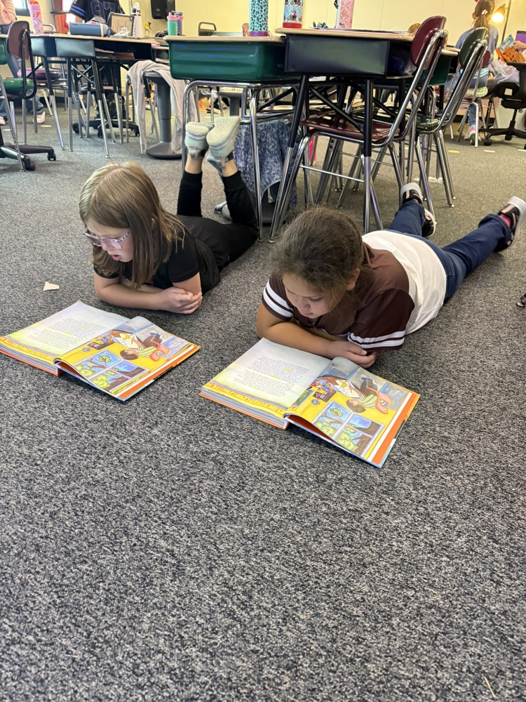 Two students reading from Wonders books together in the classroom.