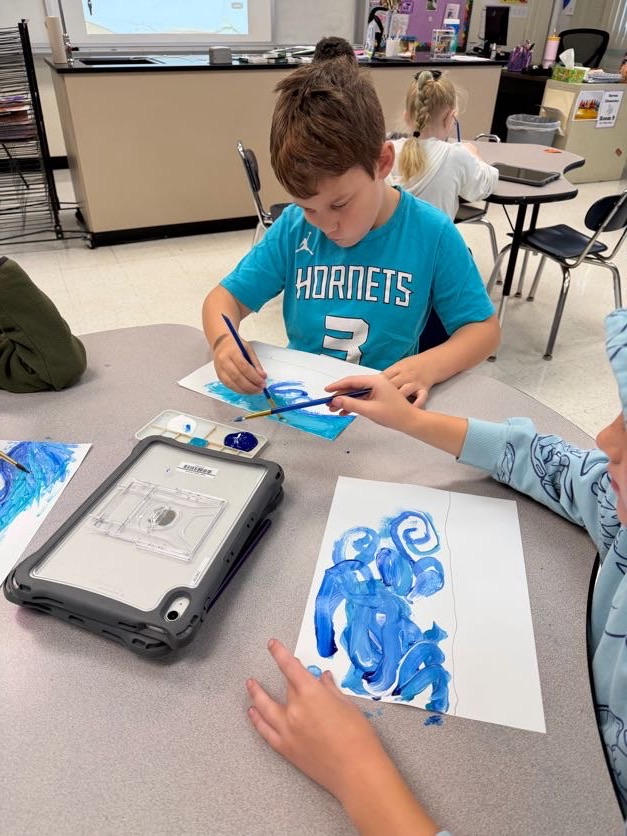 boy panting blue swirls