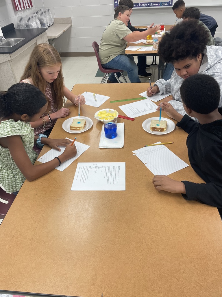 Student dropping liquid on bread.