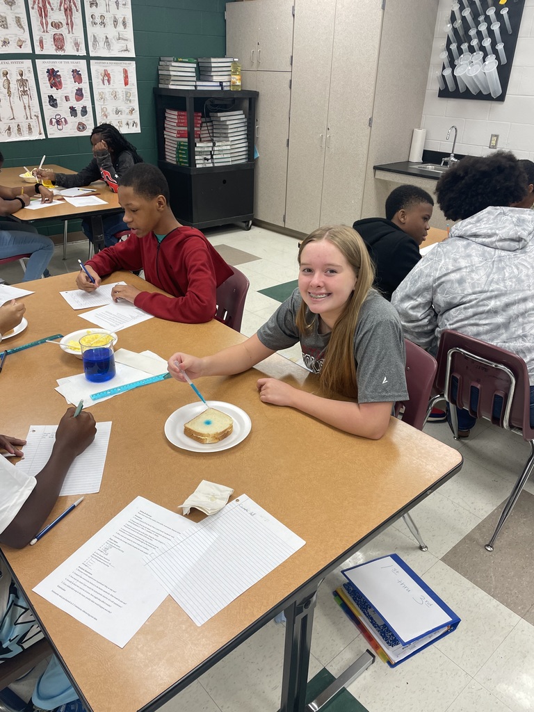Student dropping liquid on bread.