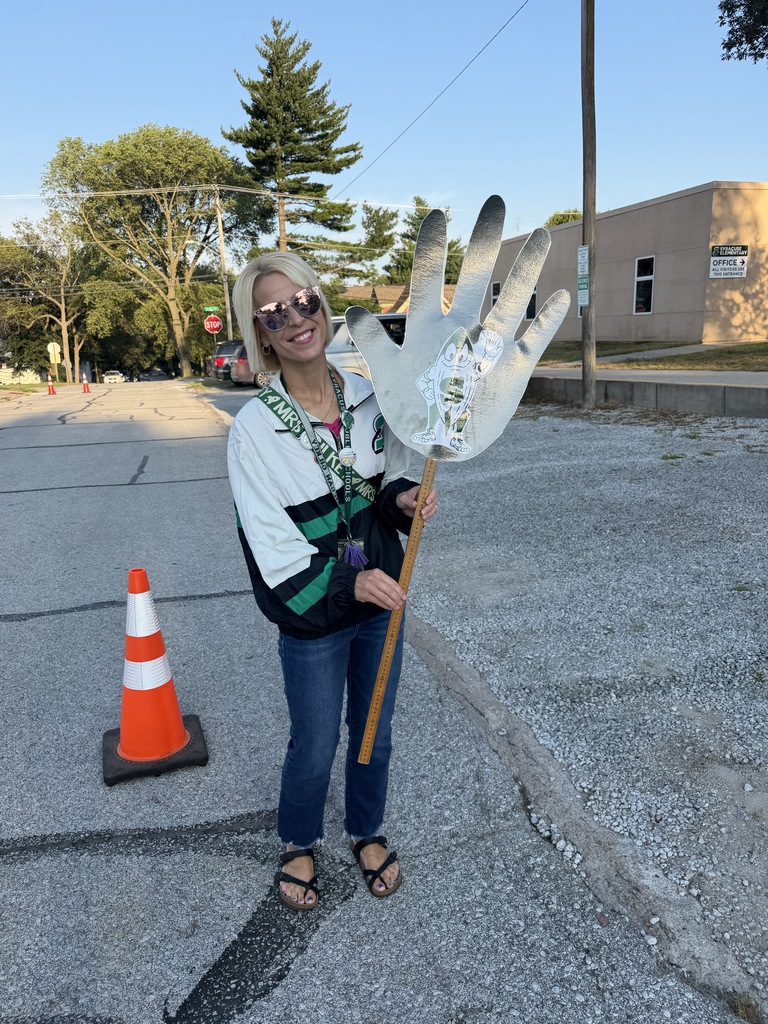 principal standing and holding a large high five