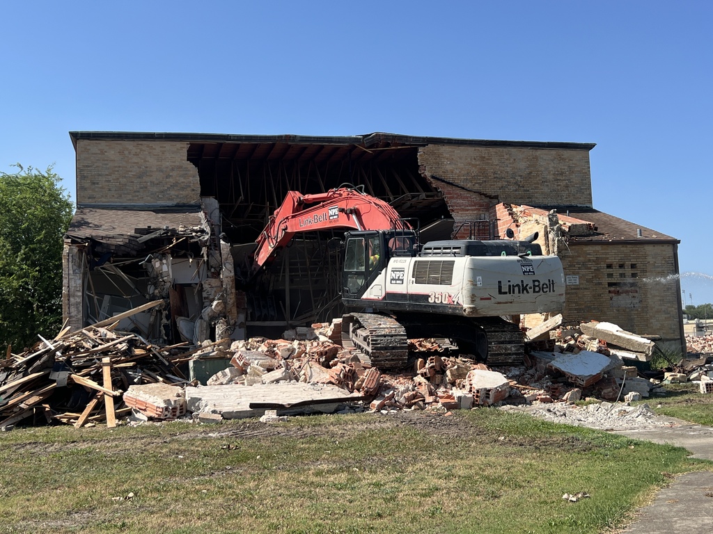 Digger completing demolition on auditorium