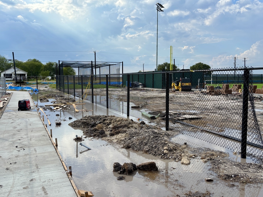 Perimeter fencing and sidewalks around softball field