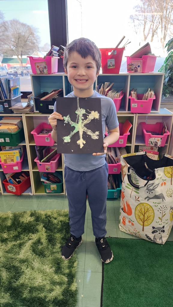 Student holding snowflake painting