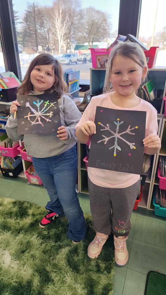 Student holding snowflake painting
