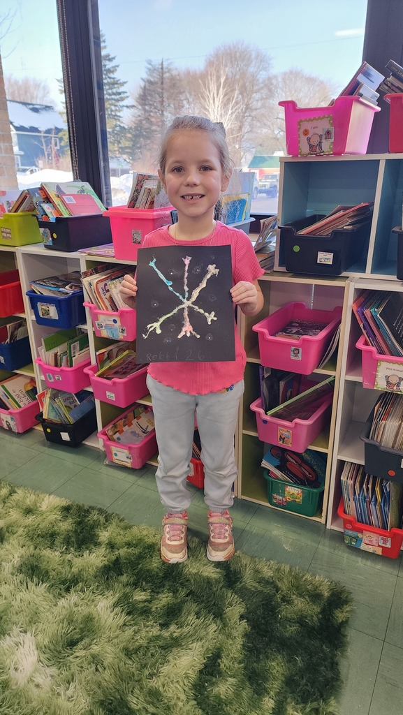 Student holding snowflake painting 