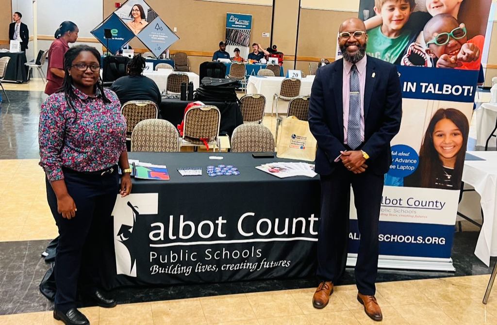 African American male on left, African American Female on right, presenting at a job fair.