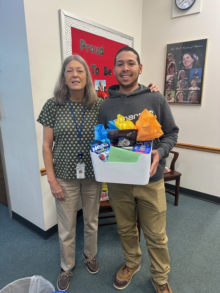Caucasian female and African American male with gift basket.