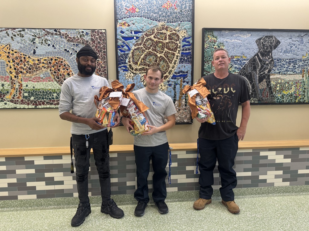 Custodians posing with gift baskets