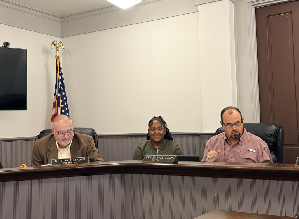 Senior sitting with board members.