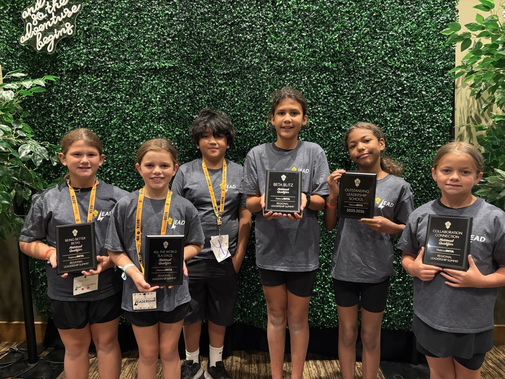 students with award plaques smiling at camera