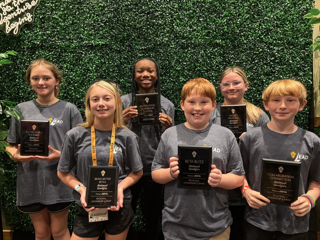 students with award plaques smiling at camera