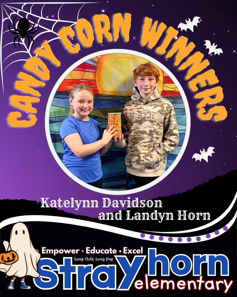 2 students smiling at the camera holding candy corn jar