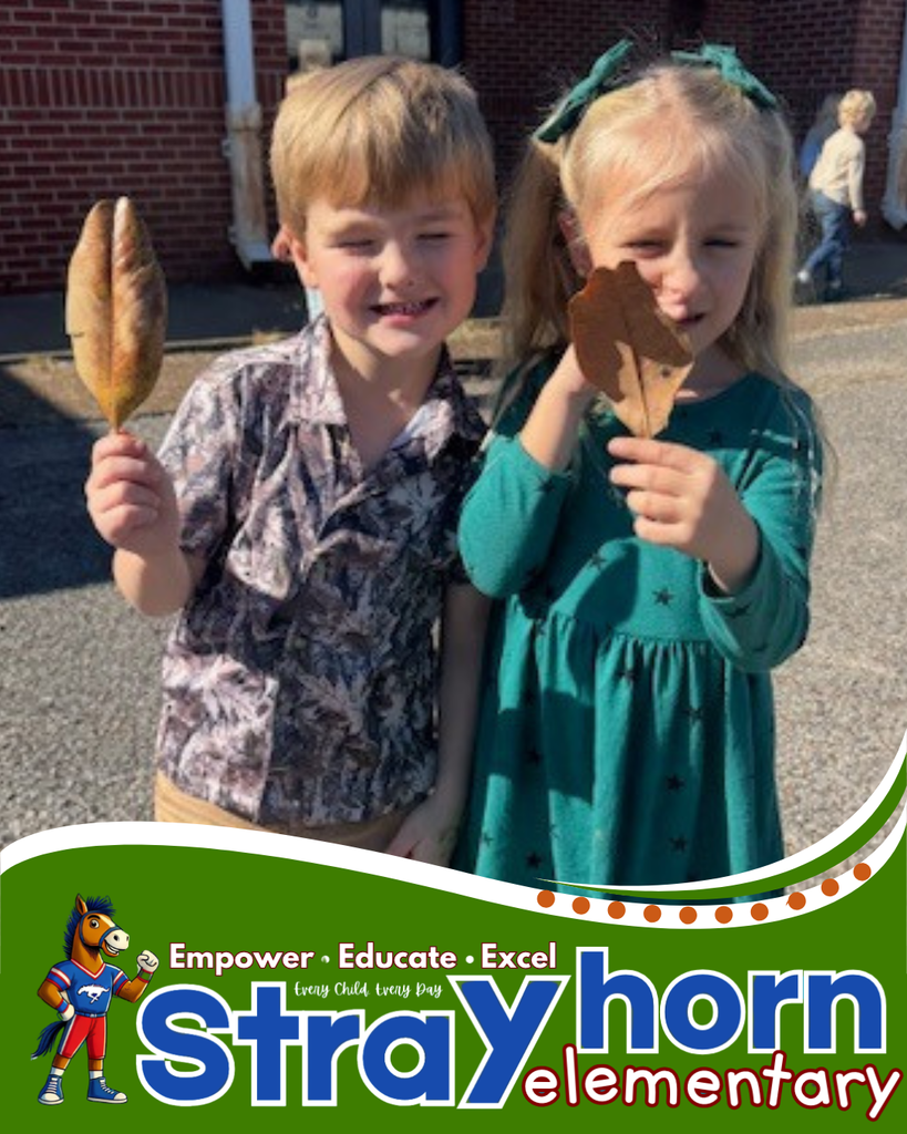 2 students holding leafs up