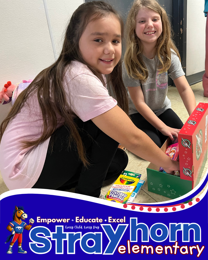2 girls packing items into a shoebox