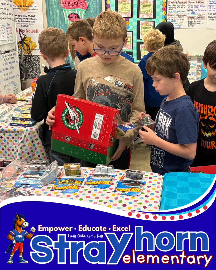 2 boys choosing items for shoebox from items on table